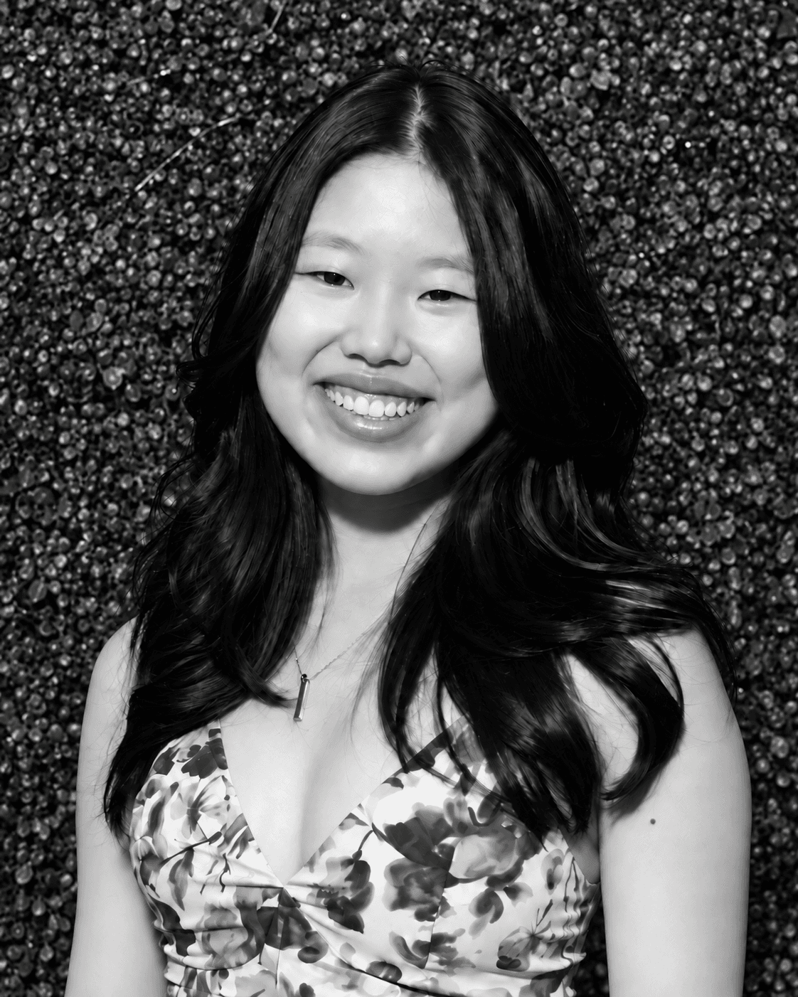 Victoria Yi smiling in front of a leafy backdrop